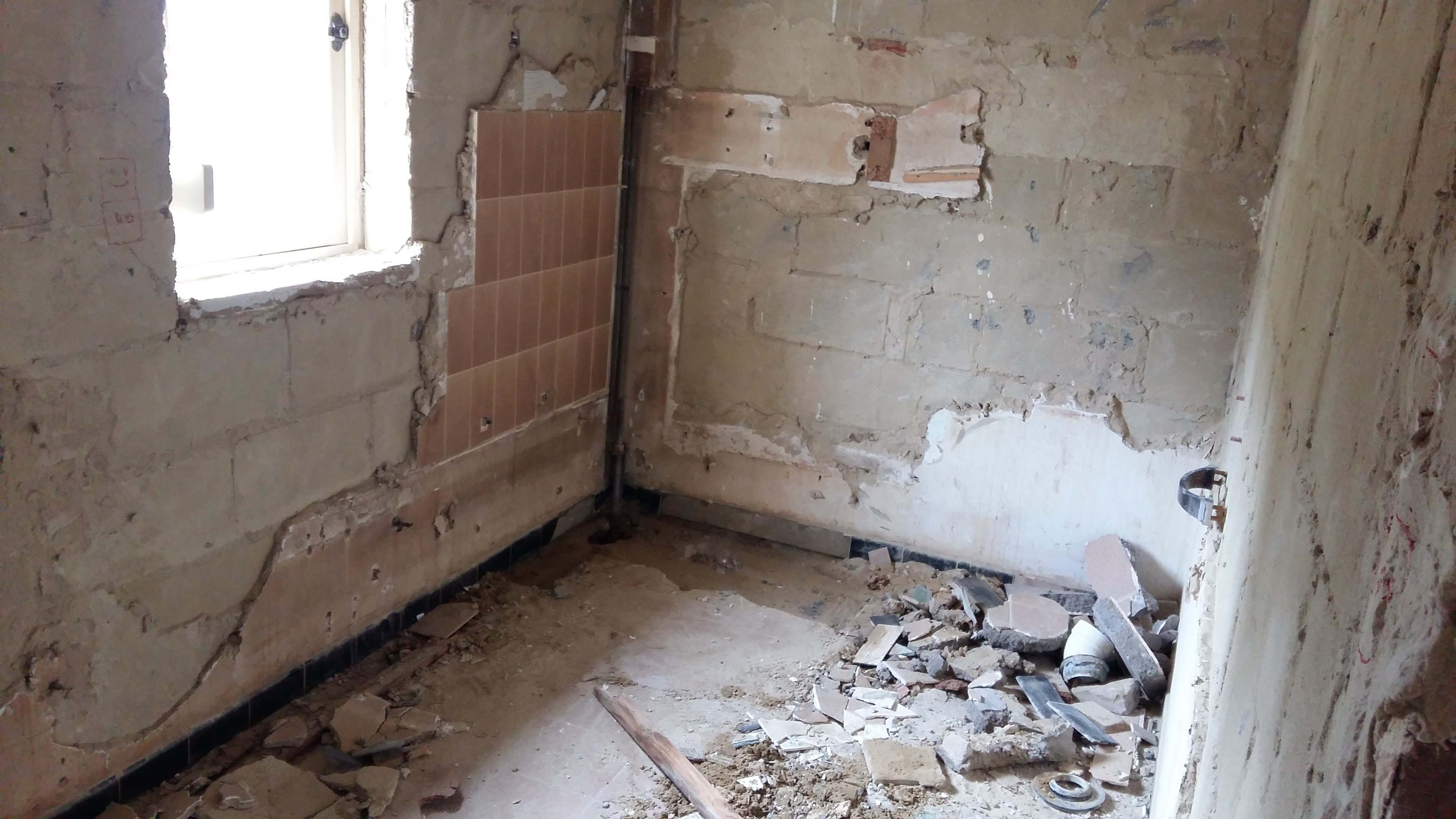 Salle de bain avant renovation gravats et murs nus - entreprise IDGS Constructions